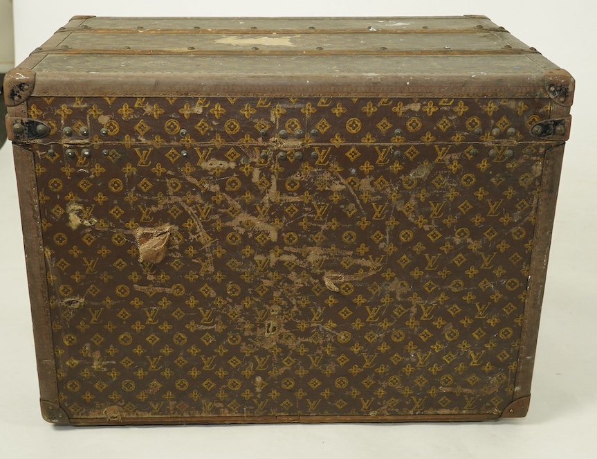 A vintage Louis Vuitton trunk, with black painted iron banding, wooden slats and canvas LV fabric, label for Paris, New Bond Street, Nice and Lille, numbered 776719, the interior with original tray, 76cm wide, 49cm deep,